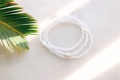 Matte Coconut white seed beads strung on stretch cord finished with a natural sea shell Bracelet can be wrapped around the wrist 3 times. Fits the average sized wrist (7 inches) The string total length is approximately 21 inches. Can also be worn as an anklet or a necklace. If you need a customized length or would like your bracelet to have more layers, please feel free to message me for a custom order! Handmade with love by Amanda 🐚 Surf wave bracelet can be found here: https://etsy.me/2DSXXfa Adjustable White Shell Beaded Bracelet, White Shell-shaped Beaded Bracelets For Vacation, Vacation Ocean-inspired Shell Beaded Bracelets, Sea Shell Bracelet, Beachy Adjustable Shell-shaped Bracelets, Surf Wave, Adjustable Shell-shaped Beach Bracelet, Wave Bracelet, White Sea