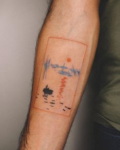 a person with a small tattoo on their arm that has a boat in the water