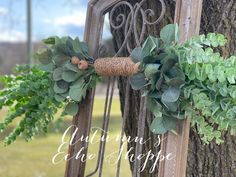 an old door is decorated with greenery and twine