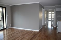 an empty living room with hard wood floors and large sliding glass doors to the outside