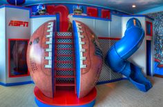 an inflatable football sits on the floor next to a blue and red slide