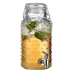 a glass beverage dispenser filled with ice and limes