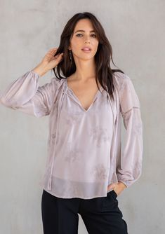 With a classic bohemian silhouette, this dreamy peasant top will be a timeless addition to your closet. Featuring delicate floral embroidery throughout, voluminous long sleeves with lattice trim, and a split v-neckline with tassel ties. We love to style this effortless blouse tucked into trousers or jeans. FINAL SALE Embroidered chiffon Relaxed fit Long voluminous sleeve Elastic wrist cuff Lace-trimmed neckline Split v-neckline with tassel ties Lattice trim throughout Sheer Removable lining Peas Spring Peasant Top With Blouson Bishop Sleeves, Feminine Long Sleeve Peasant Top With Ruffles, Elegant Peasant Top With Blouson Sleeves For Fall, Elegant Balloon Sleeve Peasant Top, Fall Peasant Top With Blouson Sleeves, Flowy Long Sleeve Peasant Top With Floral Print, Fall Peasant Top With Blouson Sleeves And Flowy Fit, Flowy Long Sleeve Floral Peasant Top, Flowy Peasant Top With Blouson Lantern Sleeves