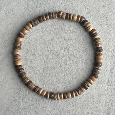 Men's beaded bracelet made with strong, stretchy cord and genuine/natural wood. Features: ~ 5mm Coconut Wood in light brown ~ Stretchy cord; simply slide bracelet on and off wrist ~ Comes packaged in a re-usable microfibre pouch Slight variations in colour may occur. More colours available!  Click on the following link to see all options: https://www.etsy.com/ca/shop/FujiBeads?ref=shop_sugg&search_query=coconut+wood To ensure the perfect fit, please use the bracelet sizing instructions found in Cheap Everyday Brown Beaded Bracelets, Brown Rustic Beaded Bracelets With Round Beads, Adjustable Wooden Beaded Bracelet, Wooden Bead Bracelet, Coconut Wood, Slide Bracelet, Wood Bead Bracelet, Bracelet Stacking, Wood Bracelet