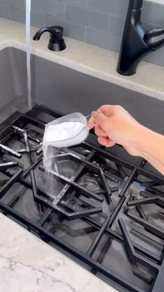 a person is washing their hands on the stove with soap and water from a faucet