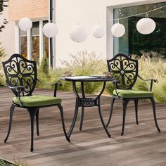 an outdoor table and chairs with green cushions