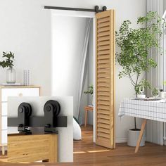 an open door in a white room next to a table with a potted plant