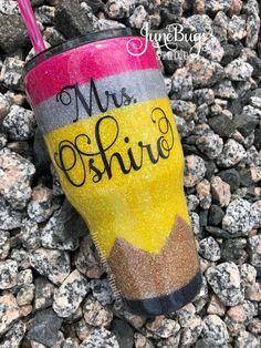 a cup that is on some rocks with the words mrs sunshine painted on it and has a straw sticking out of it