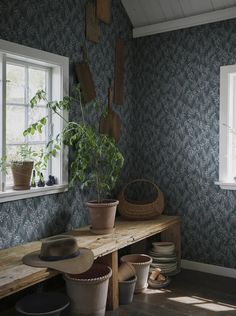 a wooden bench sitting next to a window filled with potted plants on top of it