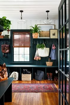 an entryway with green walls and wooden flooring is decorated with hanging planters