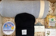 This comforting care package was curated with him in mind.  He will enjoy the blue fleece wrap blanket, a black beanie, tea tree & charcoal soap, chicken noodle soup and mini olive oil & sea salt crackers. Gift Box For Him, Sparkling Candle, Chocolate Card, Leftover Rotisserie Chicken, Charcoal Soap