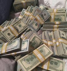 a pile of money sitting on top of a bed