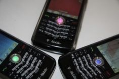 three cell phones sitting next to each other on top of a white table with green and red lights