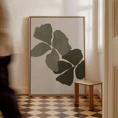 a black and white painting sitting on top of a checkered floor next to a wooden bench