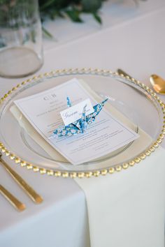 the table is set with silverware and place settings, including an elegant blue centerpiece