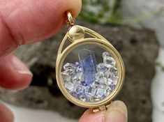 This 14K yellow gold locket has been filled with a natural terminated tanzanite crystal, and accented with faceted tanzanite gems, and sparkling Herkimer diamond quartz crystals. These are genuine and naturally occurring high grade gemstones from locations around the world, not beads or glass or synthetic stones. This high quality floating locket is US made with 14k yellow gold and glass. You will receive this exact locket and stone selection. Add on a 14K gold chain for a complete necklace, if Gold Tanzanite Jewelry With Faceted Design, Unique Tanzanite Jewelry Gift, Unique Tanzanite Jewelry For Gifts, Faceted Tanzanite Jewelry Gift, Faceted Tanzanite Jewelry For Gifts, Tanzanite Crystal, Locket Gold, Floating Lockets, Gold Locket