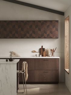 a modern kitchen with wooden cabinets and marble counter tops, along with an island in the middle