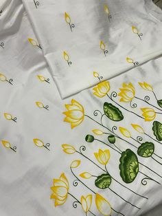 two white sheets with yellow and green flowers on them are laying next to each other