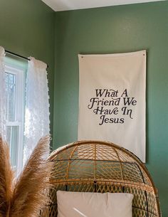 a bedroom with green walls and a white banner hanging on the wall next to a wicker bed