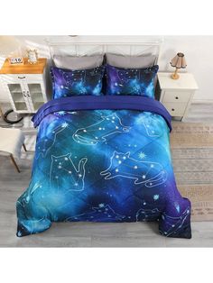 a bed covered in blue and purple sheets with stars on the sky above it, next to a white dresser