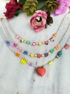 Three different multicolor summer beaded necklaces with different beads and charms. The first necklace has colorful sweets, the second one tiny flowers and the last one a unique salmon heart. Combine them all together or wear them separetely as well. In Christina Christi Jewels store you can see more than 50 designs in Women's Necklaces. You can have them in 2-4 Days with DHL EXPRESS SHIPPING MATERIALS - Caoutchouc Beads. - Freshwater Pearls. - Different type of beads - Metal Parts. - Adjustable Cute Flower Beaded Necklaces With Colorful Beads, Cute Flower-shaped Colorful Beaded Necklaces, Sweet Handmade White Necklaces, Handmade White Sweet Necklace, Dainty Multicolor Flower Necklace, Sweet Handmade White Necklace, Bohemian Rainbow Necklaces With Heart Beads, Bohemian Rainbow Necklace With Heart Beads, Cute Multicolor Beaded Necklace With Tiny Beads