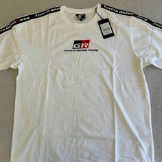 Offering A Nwt Tee From The Toyota Gazoo Racing Team. High Quality With Clothpatch Striping On Arm Sleeves And Fine Cotton Material. Will Be Posting Tees From My Brothers Collection All Day, So Get Bundling! White Graphic Tee With Three Stripes Branding, White Casual Top With Three Stripes Branding, Casual White Top With Three Stripes Branding, White Short Sleeve Tops With Three Stripes Branding, Cotton Crew Neck Tops With Three Stripes Branding, Gazoo Racing, Arm Sleeves, Racing Team, Arm Sleeve