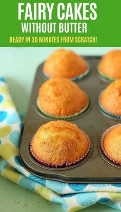 a muffin tin filled with cupcakes sitting on top of a blue and green towel