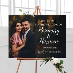 a welcome sign for a newly married couple on an easel with flowers and greenery