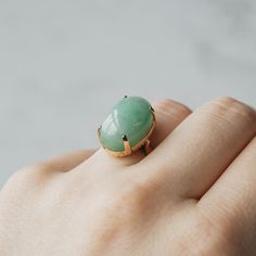 This ring is sure to be the apple of your eye. Set in 14k yellow gold, at the center sits a large piece of apple mottle jade. The granny smith color of the cabochon cut gemstone is a wonderful neutral for your everyday look. Modern Oval Jade Ring, Modern Oval Jade Jewelry, Oval Jade Ring With Natural Stones, Green Oval Gemstone Dome Ring, Estate Rings, Gem Diamonds, Contemporary Ring, Granny Smith, Jade Ring