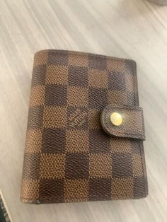 This Louis Vuitton Damier Ebene Small Ring Agenda Cover is a stylish and practical accessory for women. Made of high-quality leather, the wallet features a beautiful brown color that is perfect for any outfit. The wristlet style is perfect for on-the-go use, and the small size makes it easy to carry in your purse or bag.The wallet is designed with the renowned Louis Vuitton brand, and its elegance is perfect for women who appreciate fashion. The Damier Ebene pattern is unique and stylish, making it a must-have accessory for any fashion-forward woman. This wallet is perfect for keeping your everyday essentials organized, and its small size makes it easy to carry in your purse or bag. Agenda Cover, Small Ring, Louis Vuitton Damier Ebene, Small Rings, Damier Ebene, Everyday Essentials, High Quality Leather, Louis Vuitton Damier, Brown Color