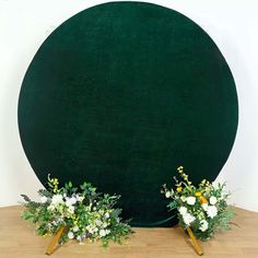 two vases filled with flowers sitting on top of a wooden floor next to a green wall