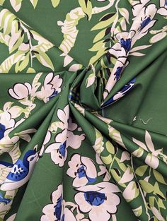 a green and blue floral print fabric with white flowers on it's center piece