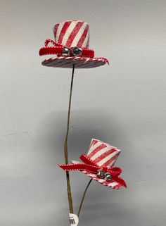 two red and white straw hats on top of each other in the shape of flowers