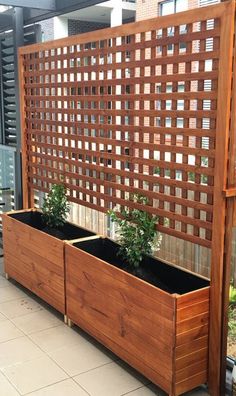 a wooden planter with two plants in it