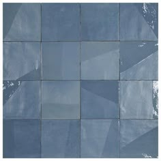 a blue tiled wall with white and gray squares on it's sides, as well as the bottom half