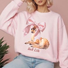 Soft Life Coquette Deer with Pink Bow Crewneck Sweatshirt is a cozy and stylish addition to your wardrobe. Perfect for the colder months, this sweatshirt offers a clean-cut style with a comfortable classic fit. It features double-needle stitching for durability and a tear-away label for itch-free wear. The design of the Coquette Deer with Pink Bow adds a touch of whimsy to your outfit, making it perfect for casual wear or lounging at home. Ideal for deer lovers and those who appreciate cute and feminine designs. Great for Christmas gifting, winter celebrations, or everyday wear. Product features - Classic fit with crew neckline for comfort - Medium-heavy fabric blend of 50% cotton and 50% polyester for coziness - Double-needle stitching for durability - Ribbed knit collar for shape retenti Kawaii Crew Neck Sweatshirt, Cute Sweater With Letter Print For Loungewear, Cute Letter Print Sweater For Loungewear, Pink Kawaii Sweatshirt, Sweet Pink Long Sleeve Sweatshirt, Cute Pink Sweater For Loungewear, Cute Pink Long Sleeve Sweatshirt, Pink Cute Sweater For Loungewear, Cute Long Sleeve Sweatshirt For Loungewear