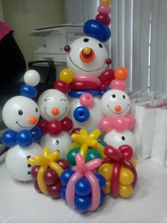 balloons are arranged in the shape of snowmen and clowns on a white table