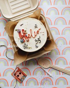 a cake in a box with the word love spelled on it and some spoons next to it