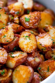 cooked potatoes with parsley in a white bowl