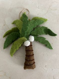 a felt palm tree ornament hanging on a wall