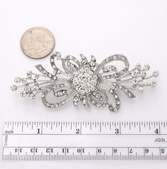 "Beautiful rhinestone silver brooch jewelry embellishment, which can be used for your DIY project - Vintage brooch bouquet, bridal gown sash, necklace, cake decorations, event decor, crafts, scrap booking, jewelry gift and much more. Size: 3 3/4\"W x 1 1/2\"H Stones color: Crystal clear Metal: Silver plated This crystal silver brooch can be ordered with pin in the back to add to wedding gown or dress sash, to wire into brooch bouquet, or any number of other craft projects; or without the pin as Elegant Silver Crystal Pins, Silver Crystal Pins For Wedding, Silver Crystal Wedding Pins, Silver Crystal Brooch For Anniversary, Silver Crystal Brooches For Anniversary, Silver Crystal Brooch Pin, Wedding Crystal Brooch Pins, Silver Crystal Anniversary Brooches, Wedding Crystal Pins With Rhinestones