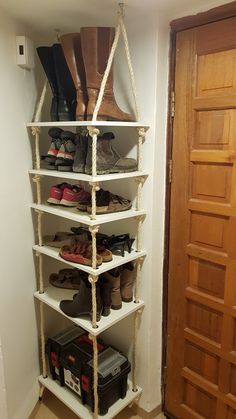 a white shelf with several pairs of shoes hanging from it's sides in a room