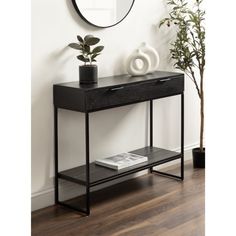 a black console table with a mirror on the wall