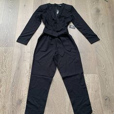 This Beautiful Jumpsuit From Express Features A Deep V-Neck, With Tie Belt At The Waist, Long Sleeves, Slash Pockets And A Tapered Leg. Msrp $108 Size Small Color Black Chic Long Sleeve Pantsuit In A Solid Color, Chic Solid Color Long Sleeve Pantsuit, Chic Fitted V-neck Pantsuit, Fitted V-neck Jumpsuits And Rompers For Going Out, Fitted V-neck Jumpsuits And Rompers For Date Night, Belted V-neck Jumpsuit For Night Out, Solid Long Sleeve Pantsuit For Party, Fitted Long Sleeve Pantsuit For Night Out, Fitted Belted Jumpsuits And Rompers For Date Night