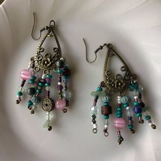 I made these spunky dangling earrings with lots of different kinds of beads, some are real crystal beads and some are just normal. I put in beads from some bracelets ive broken including a Chinese coin style bracelet. The base of these earrings include great detail and a floral design. Vintage Dangle Beaded Earrings For Festival, Unique Adjustable Beaded Earrings With Dangling Beads, Beaded Metal Crystal Earrings, Colorful Beads Dangle Jewelry, Colorful Beaded Metal Dangle Jewelry, Multicolor Metal Bead Dangle Jewelry, Festival Dangle Earrings With Dangling Beads, Multicolor Metal Bead Jewelry With Dangling Beads, Multicolor Dangling Beads Metal Jewelry