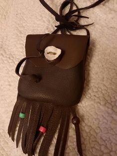 Hello, this is a deerskin medicine pouch made from a 4/5 z deerskin tanned chocolate brown and sewn with artificial sinew. It measures approximately 3.5" wide x 4.5" high. There are assorted beads on the fringe. The flap is secured by an antler button. Dave Whimsical Jewelry, The Fringe, Antlers