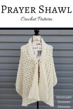 a white crocheted shawl on a mannequin with the words prayer shawl written below it