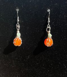 Orange dyed agate pumpkin earrings wire wrapped in silver colored copper with green accent beads Wire Wrapped Agate Dangle Jewelry, Orange Jade Jewelry Gift, Orange Czech Glass Jewelry With Ear Wire, Wire Wrapped Czech Glass Drop Earrings, Handmade Orange Agate Jewelry, Distinctive Silver Wire Wrapped Beaded Earrings, Unique Silver Wire Wrapped Beaded Earrings, Green Copper Wire Earrings Gift, Wire Wrapped Agate Earrings For Gift