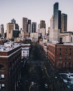 an aerial view of a city with tall buildings and cars parked on the street in front of them