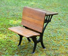 a wooden bench sitting on top of a lush green field